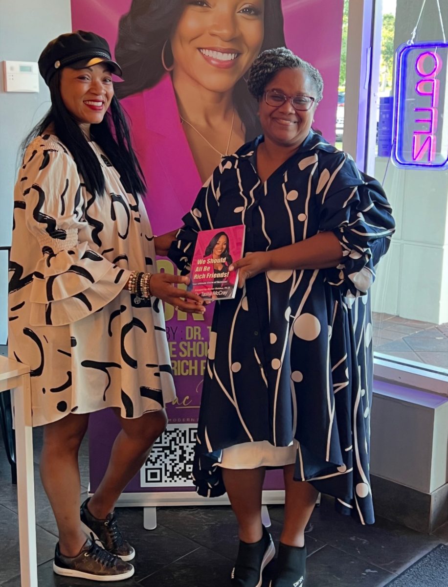 A reader in her work uniform holding the book with Dr. TMac