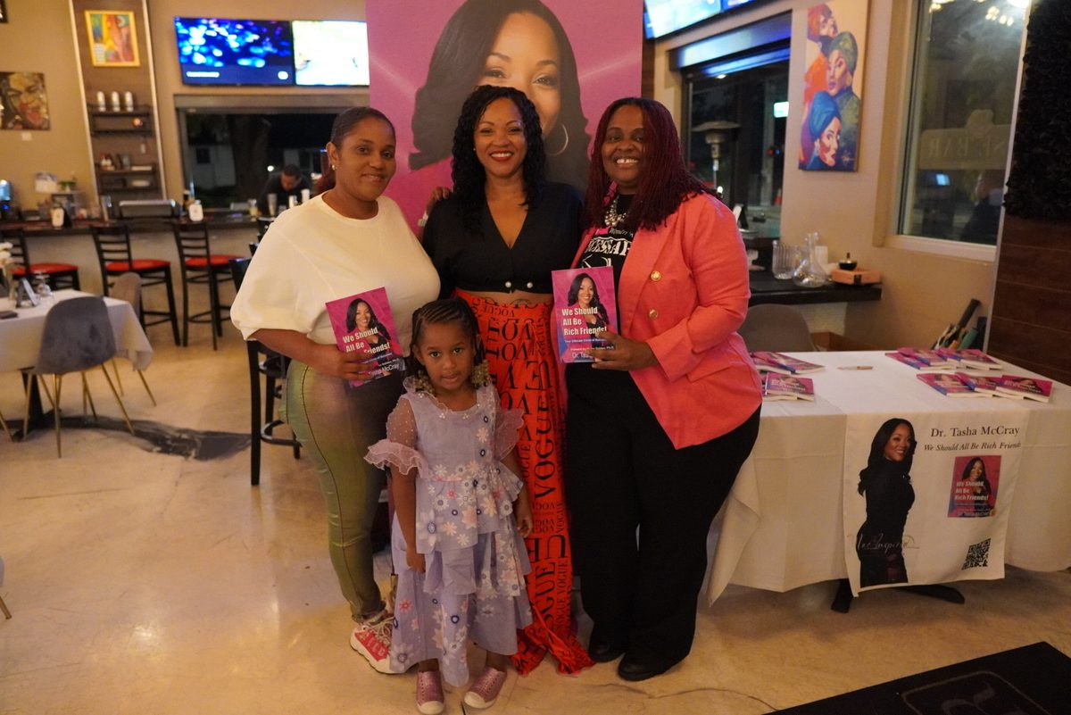 A family holding the book with Dr. TMac