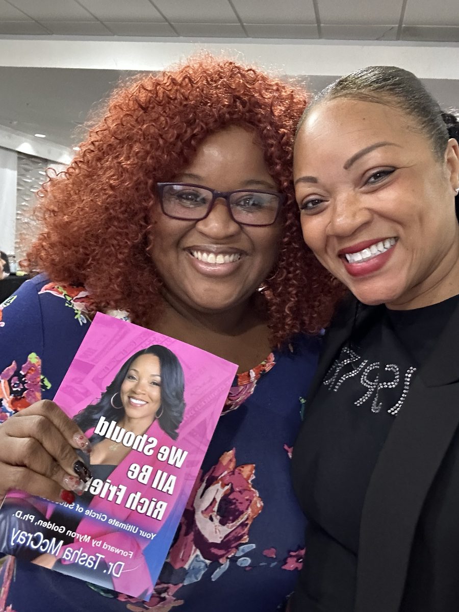 Two readers in Hey Rich Friends shirts holding the book