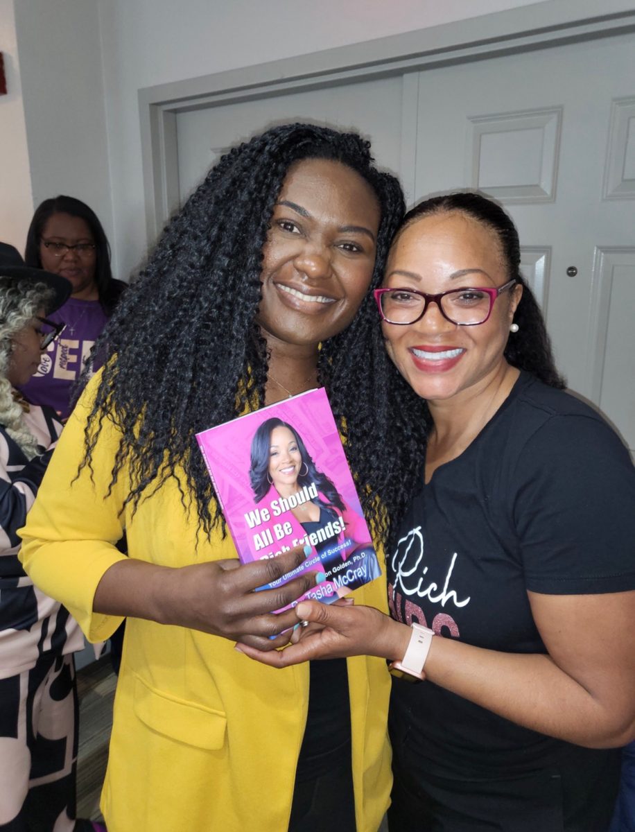 A reader holding the book with Dr. TMac in a Rich Friends shirt